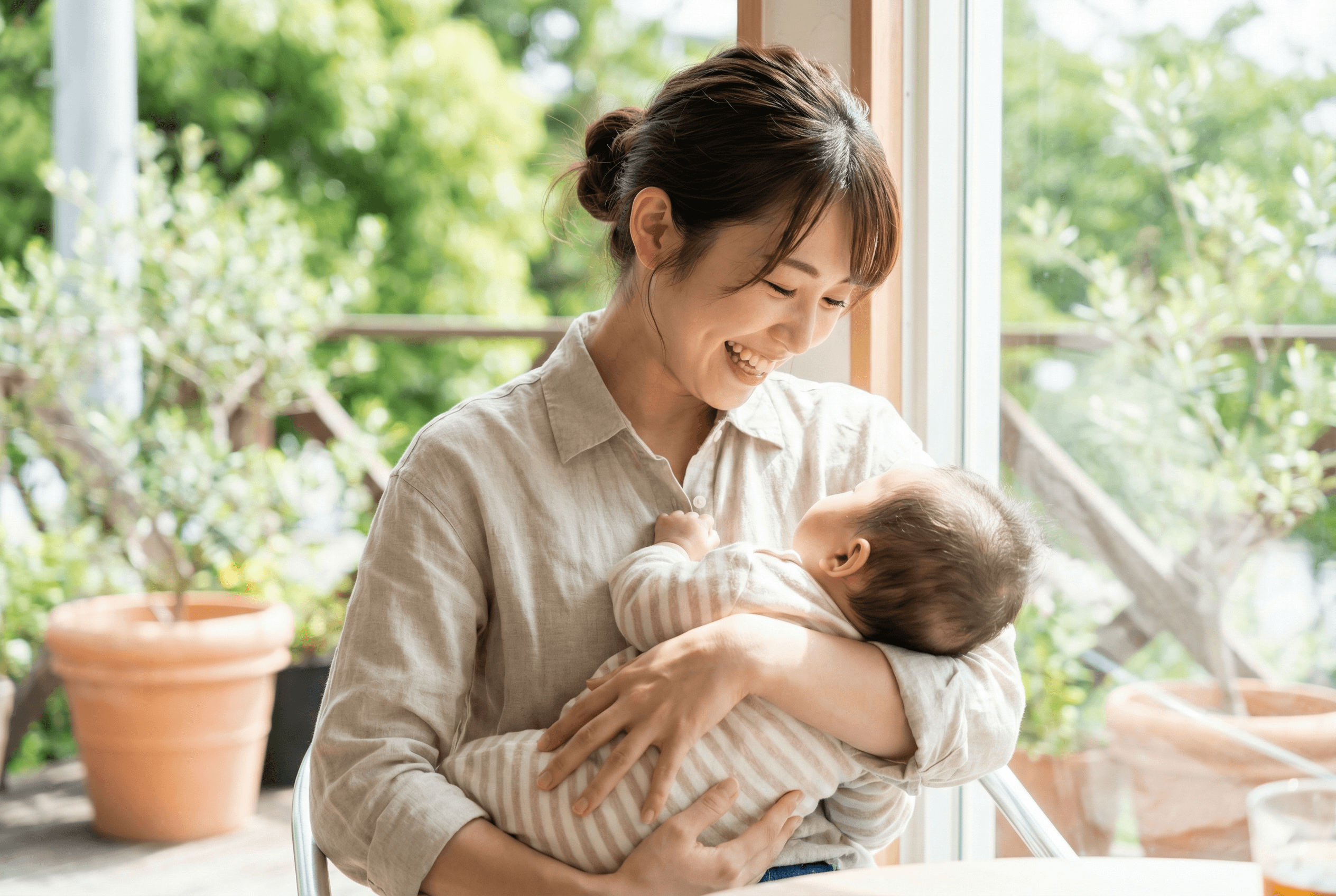ママが笑顔で赤ちゃんを抱っこしているイメージ